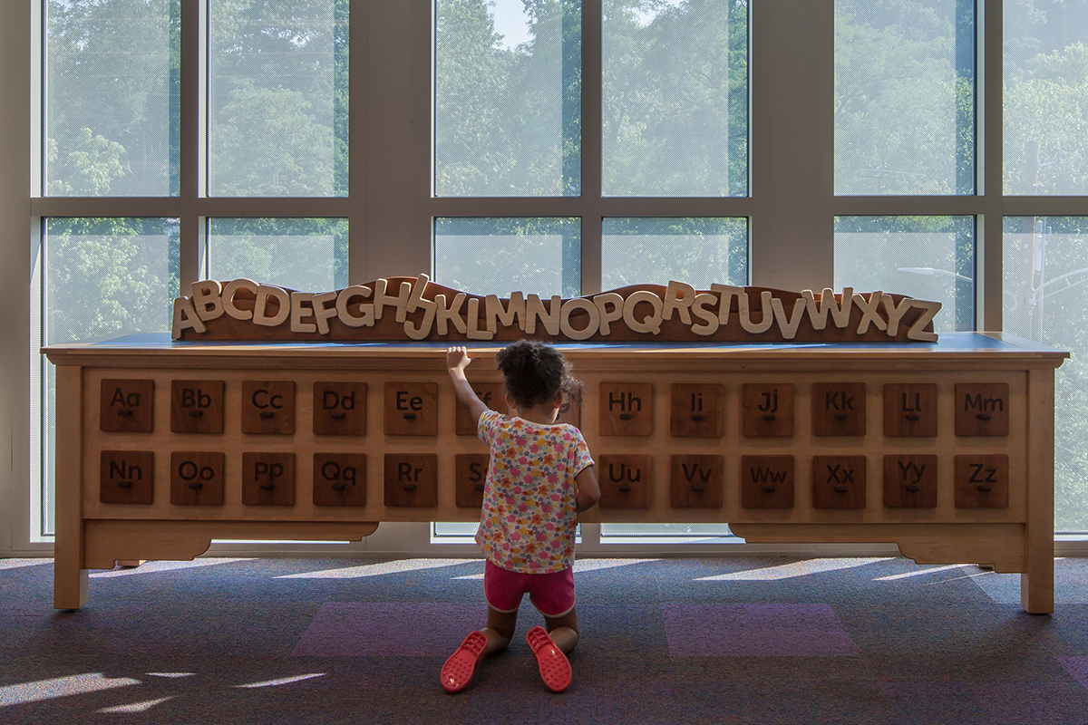 girl playing with a card catalog exhibit
